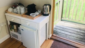 A kitchenette with a microwave, a coffee maker, and various kitchenware on a countertop. - Rosebank Bed & Breakfast (Etchingham)