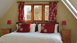 A bedroom with a bed, two nightstands, and a window with curtains. - Rosebank Bed & Breakfast (Etchingham)