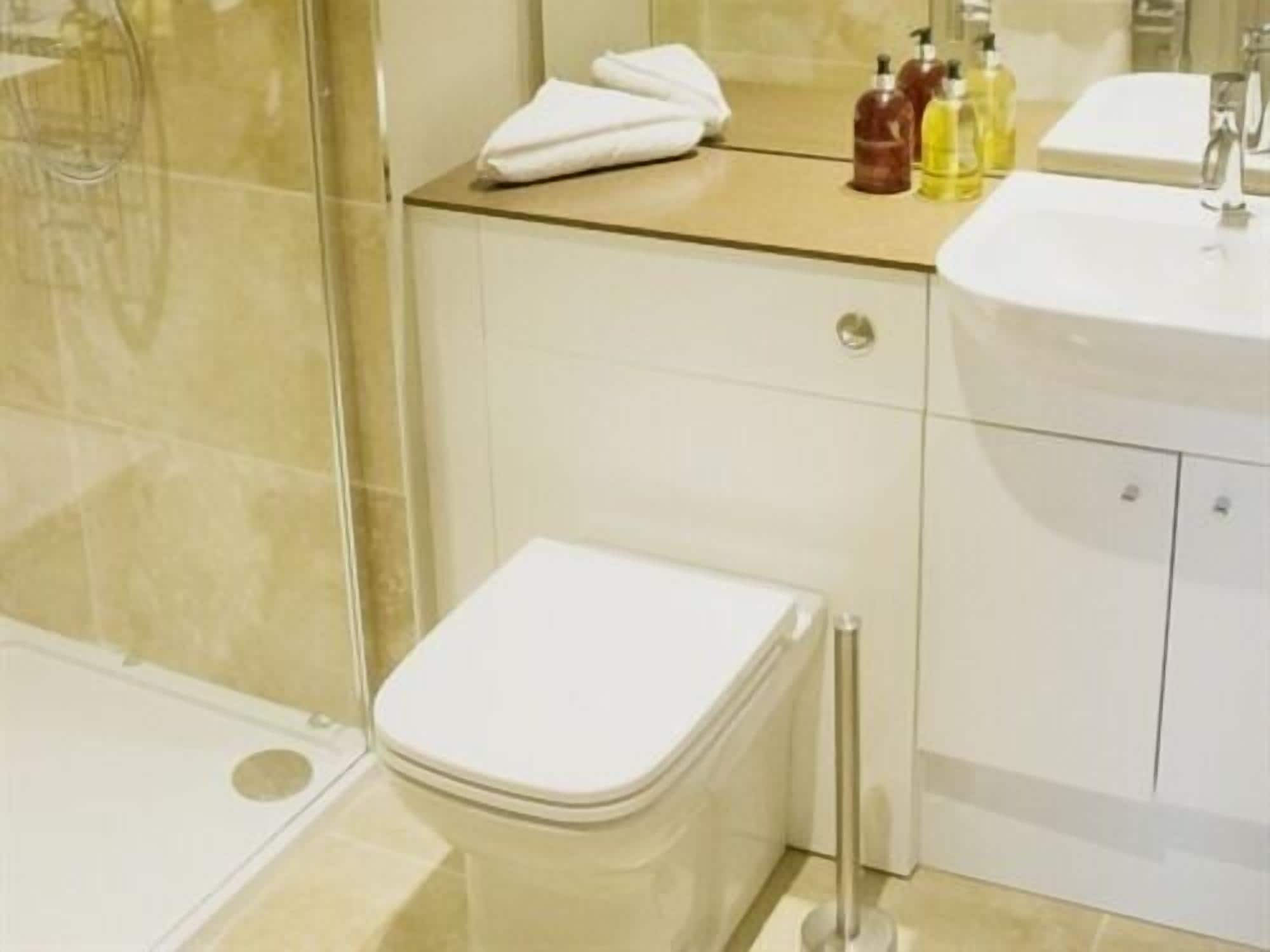 A modern bathroom with a toilet, sink, and shower.