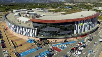 A large, circular building with a curved roof, surrounded by a parking lot with blue handicap parking spaces.