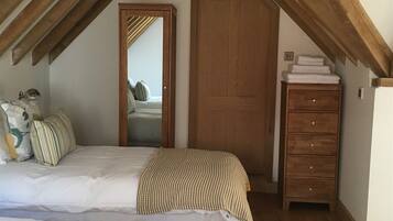 Ein Schlafzimmer mit zwei Betten, einem Holzschrank und einem Spiegel.