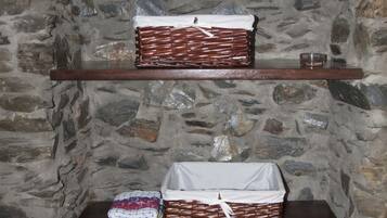 Een stenen muur met twee houten planken, elk voorzien van manden en een textielproduct.
