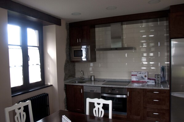 Una cocina con microondas, lavavajillas y una caja sobre la encimera.