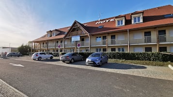 A hotel with a red-tiled roof, multiple balconies, and a sign indicating it is an apartment hotel.