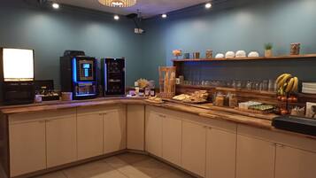 A modern kitchen area with a coffee machine, a bread basket, and various food items on the counter.