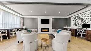 Un salon moderne avec des canapés gris, une table basse en bois et une cheminée.