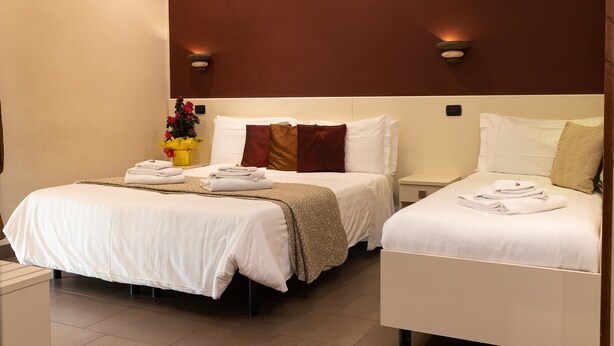 Een hotelkamer met twee bedden, een tafeltje en een nachtkastje.