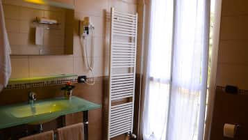 Une salle de bain avec un lavabo en verre, un porte-serviettes et une serviette blanche suspendue.