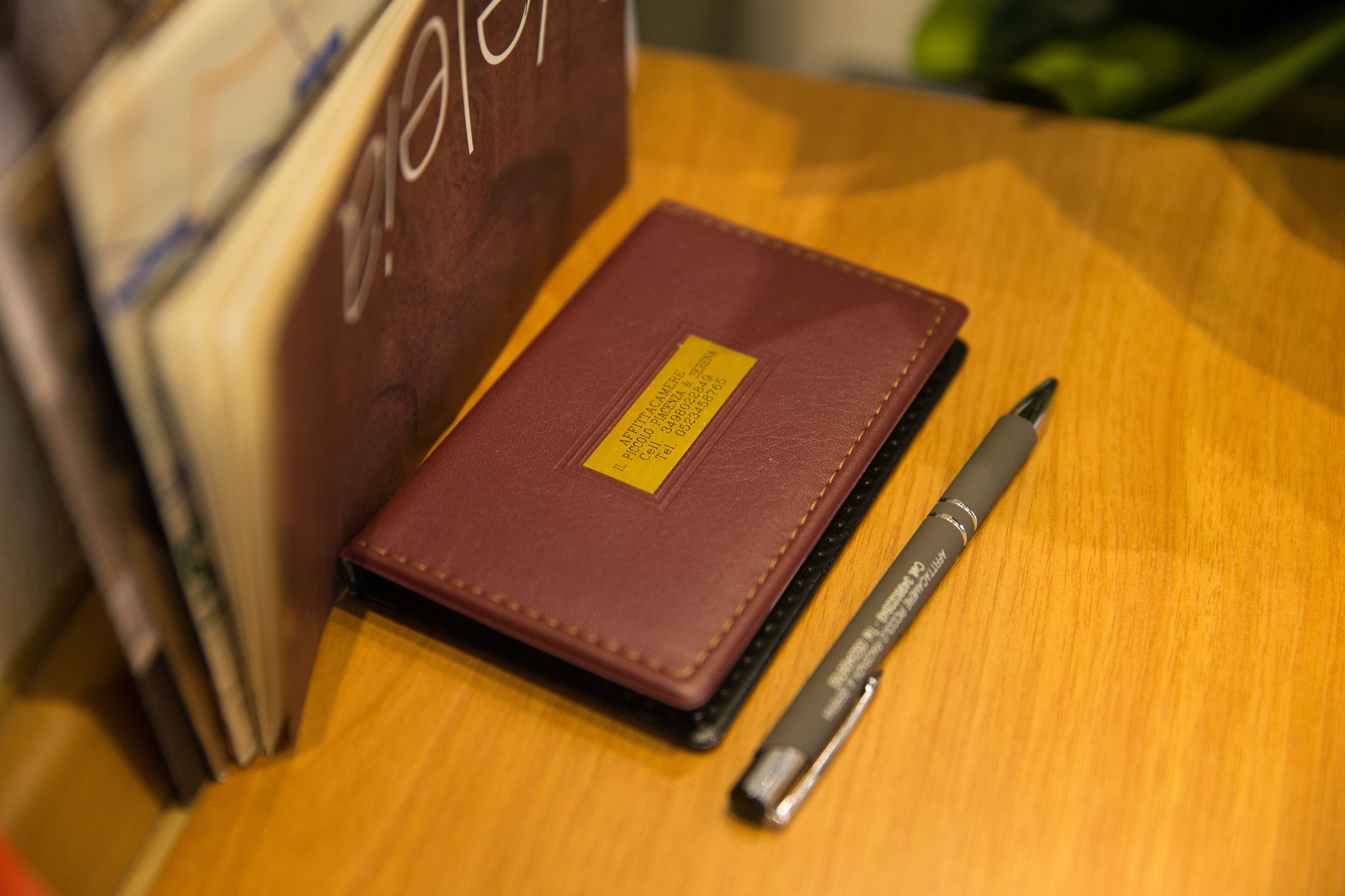 A brown leather-bound notebook with a yellow label on a wooden surface.