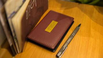 A brown leather-bound notebook with a yellow label on a wooden surface.