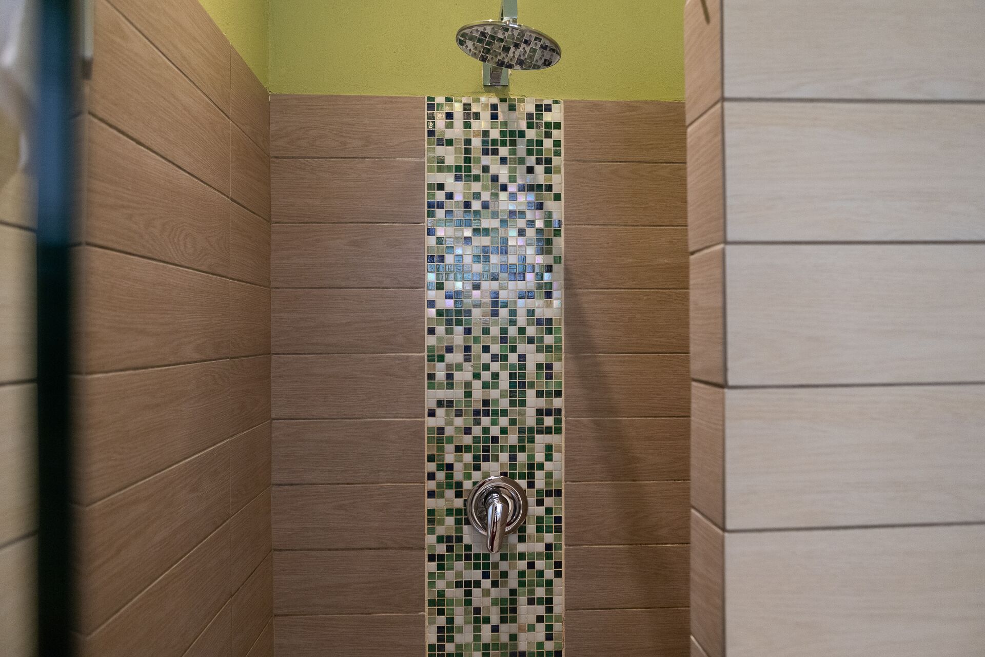 A shower area with wooden walls and a tiled wall.