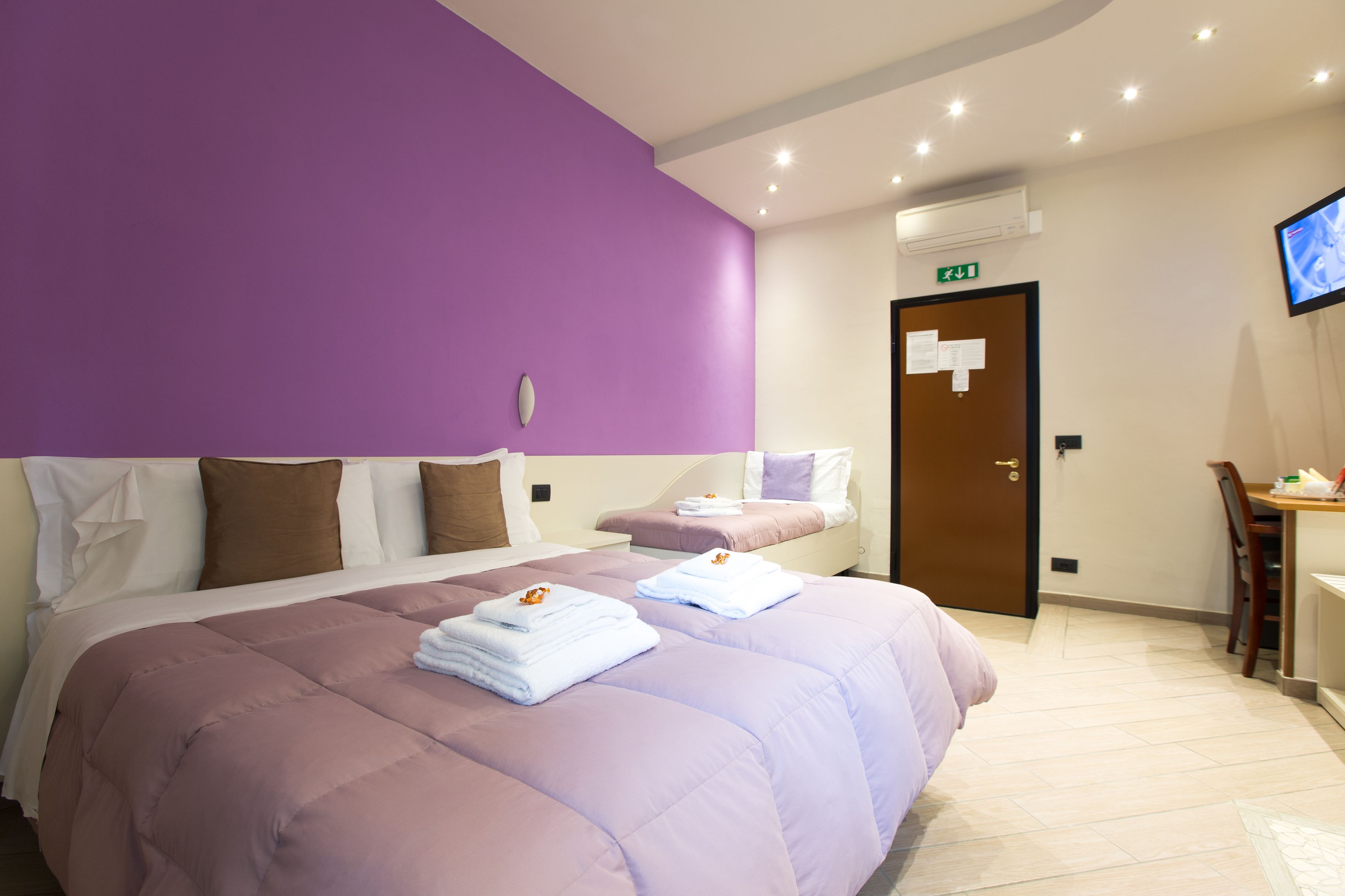 Une chambre d’hôtel avec un grand lit, un bureau et une télévision.