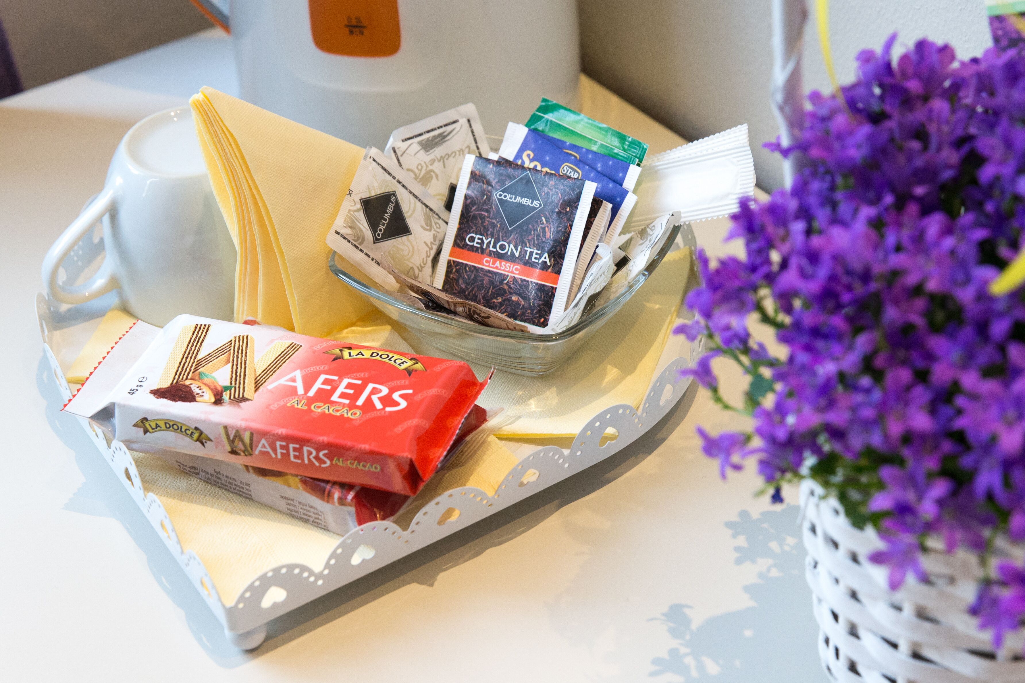 A tray with a mug, tea packets, and chocolate wafers.