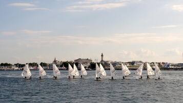 Enjoy serene waterway views with sailboats and a historic lighthouse nearby.