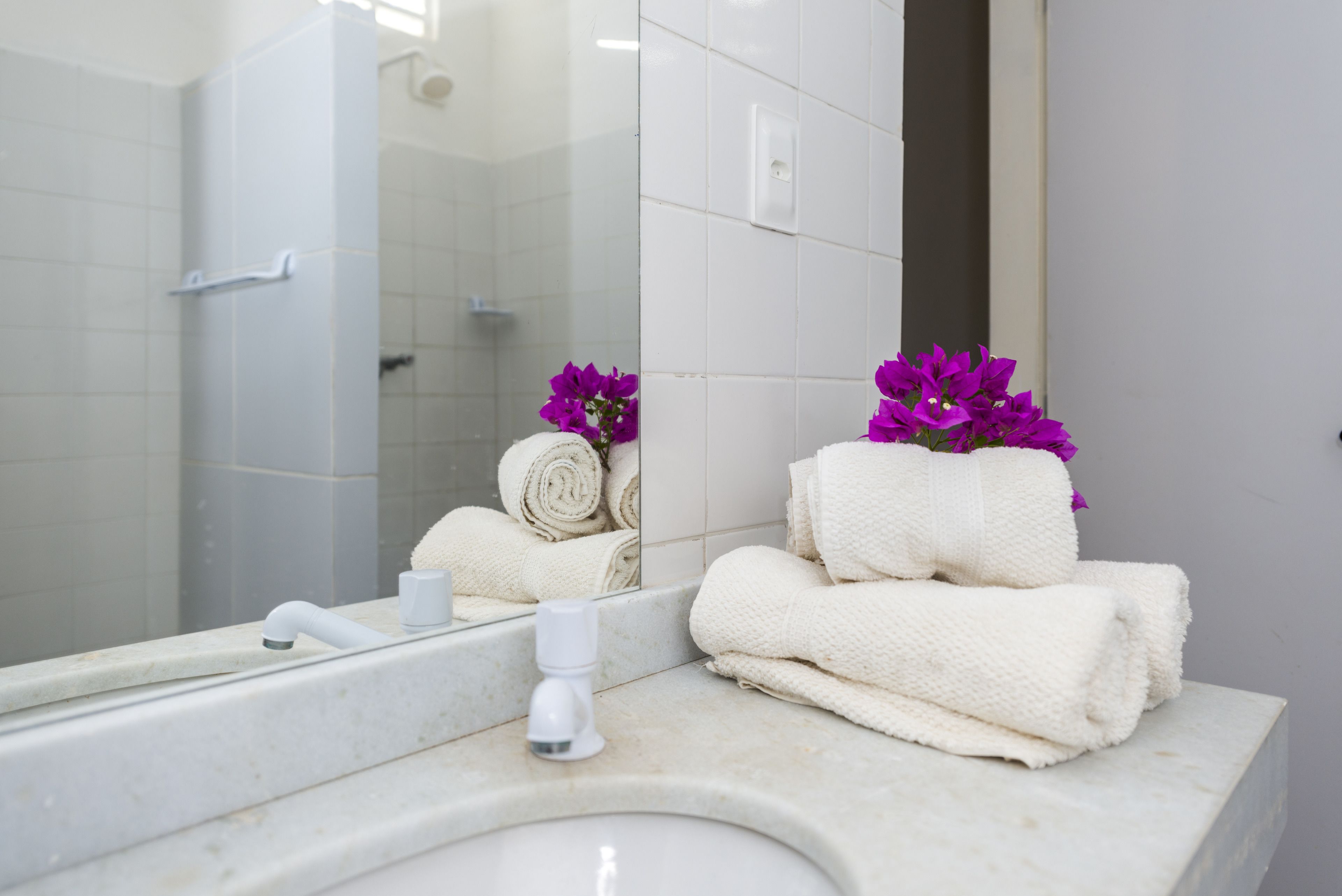A bathroom with a white sink, a mirror, and towels.