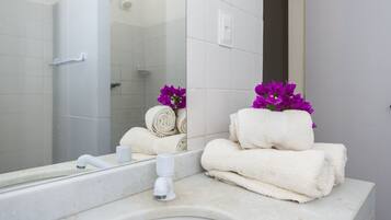 A bathroom with a white sink, a mirror, and towels.