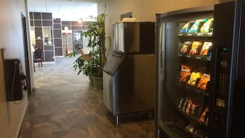 En korridor med en automattankstation fylld med snacks, en krukväxt och ett kylskåp.