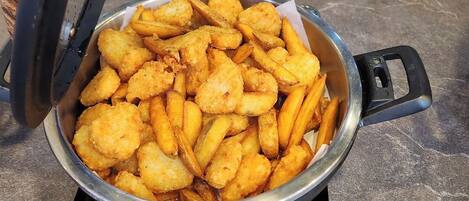 A pot of golden-brown fried food on an induction cooktop.