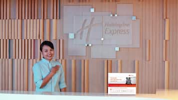 A person standing at a reception desk with a Holiday Inn Express sign in the background.