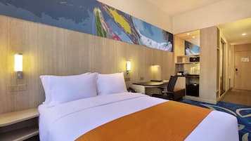 Quarto de hotel com uma cama grande, escrivaninha e micro-ondas.