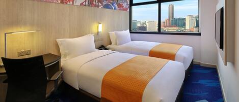 A hotel room with two beds, a desk, a chair, a lamp, and a large window with a city view.