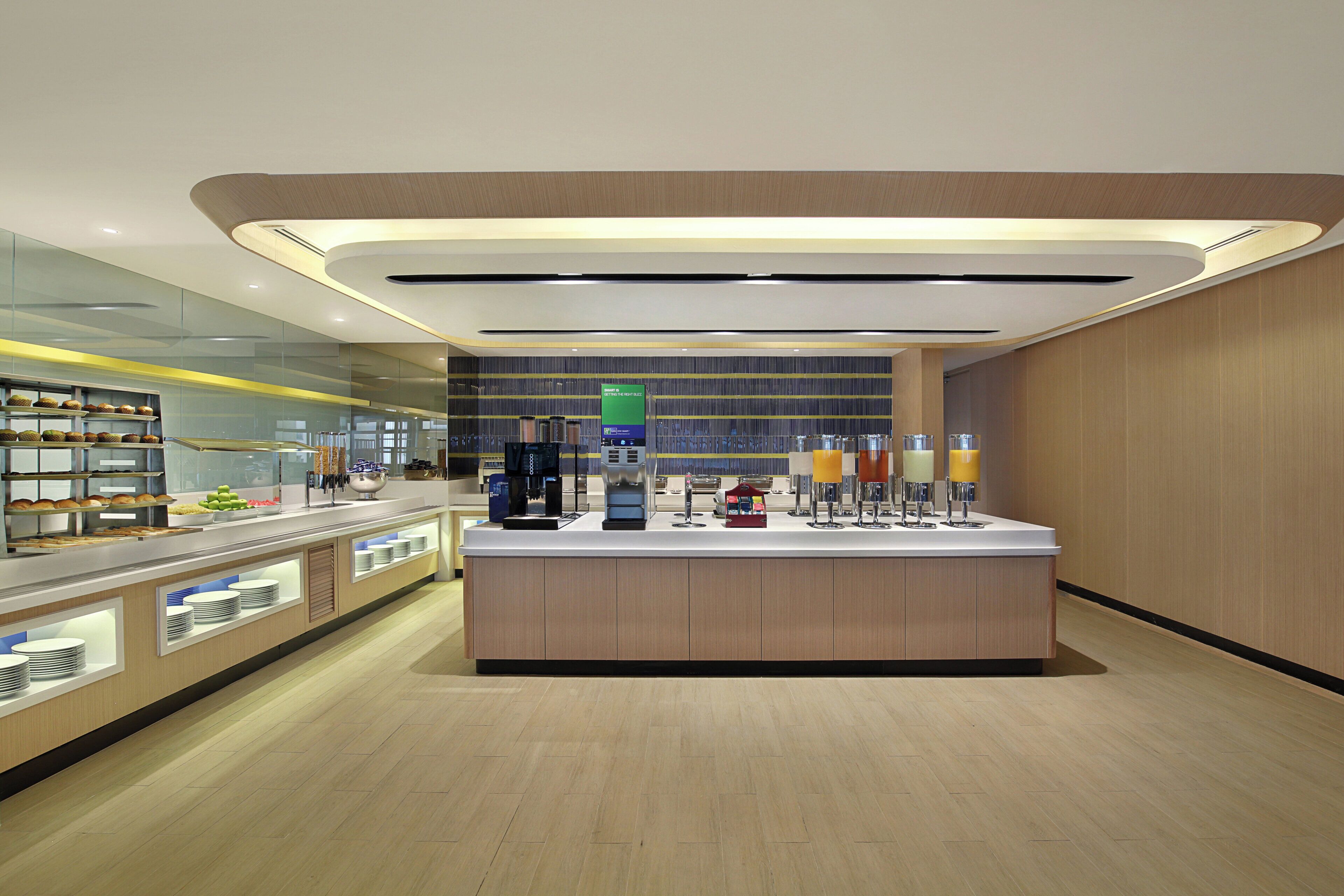A modern cafe with a central island, counter, and various food and drink options.