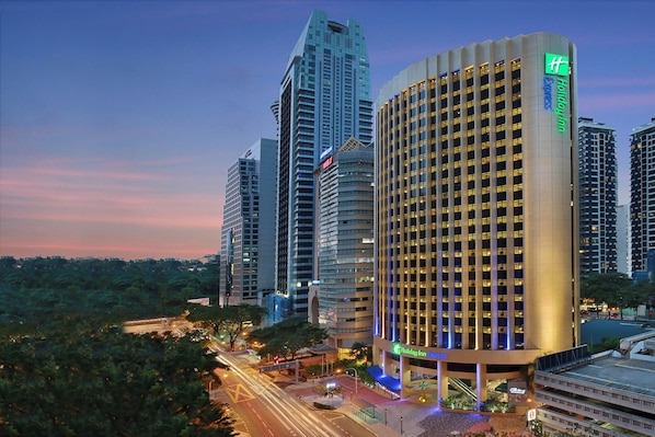 A high-rise hotel with a prominent 'Holiday Inn Express' sign, surrounded by other tall buildings and a busy street with traffic lights. - Holiday Inn Express Kuala Lumpur City Centre by IHG (Kuala Lumpur)