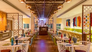Un restaurant doté d’un bar central, de nombreuses tables et de chaises.
