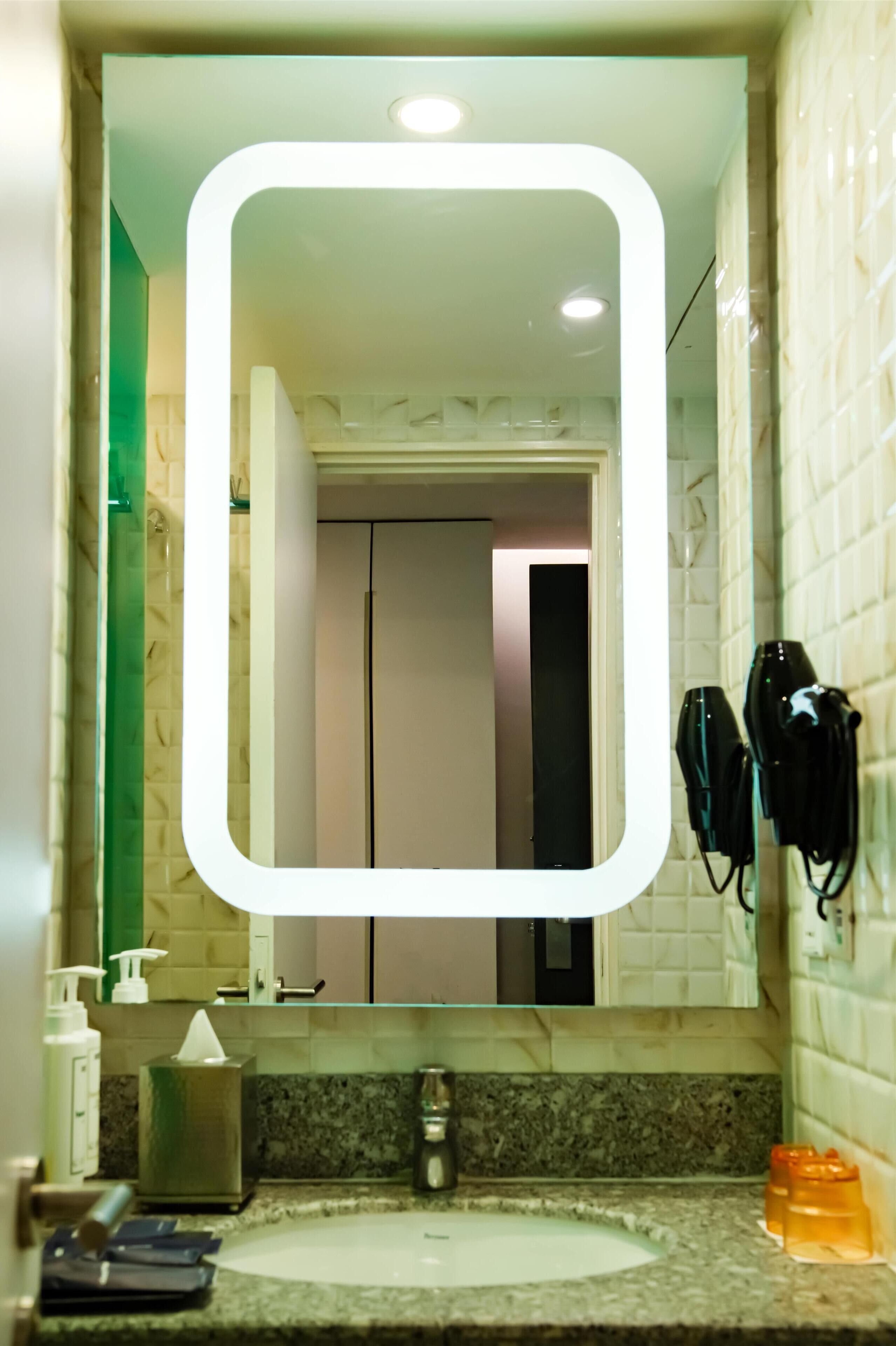 A bathroom with a white sink, a mirror, and a towel rack.