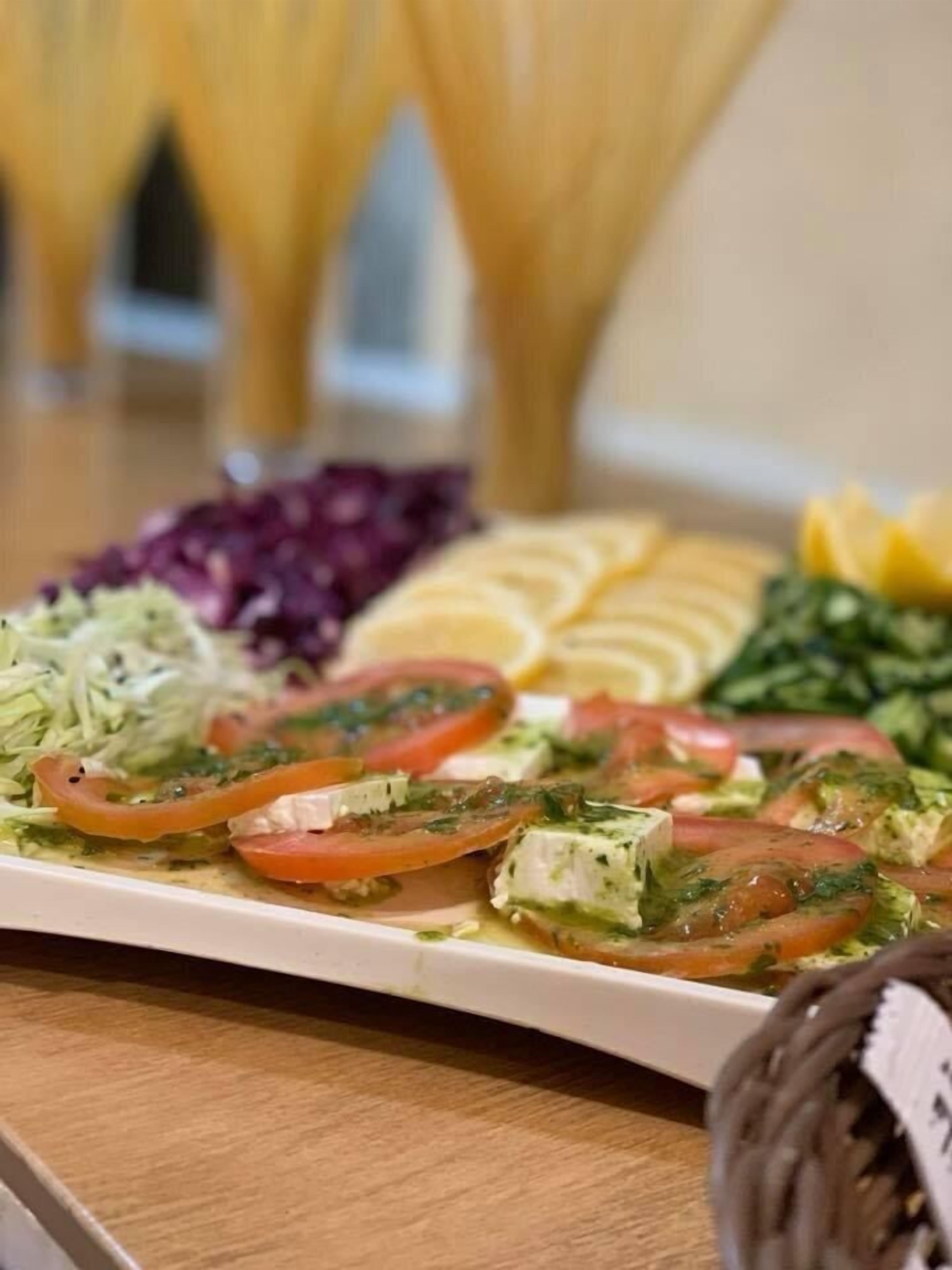 Un plato de comida con diversas verduras y un plato blanco.