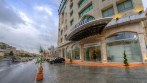 Et hotel med en moderne facade, store vinduer og et overdækket indgangsparti.