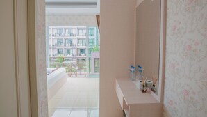 A bathroom with a large mirror, a sink with toiletries, and a view of a balcony with outdoor furniture. - Jasmine House @ Pattaya (Pattaya)
