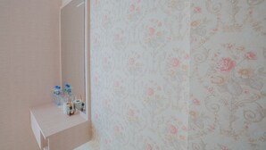 A bathroom with a wooden vanity, a mirror, and floral wallpaper. - Jasmine House @ Pattaya (Pattaya)