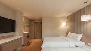 Une chambre d’hôtel avec deux lits, une télévision, un bureau et une salle de bain.