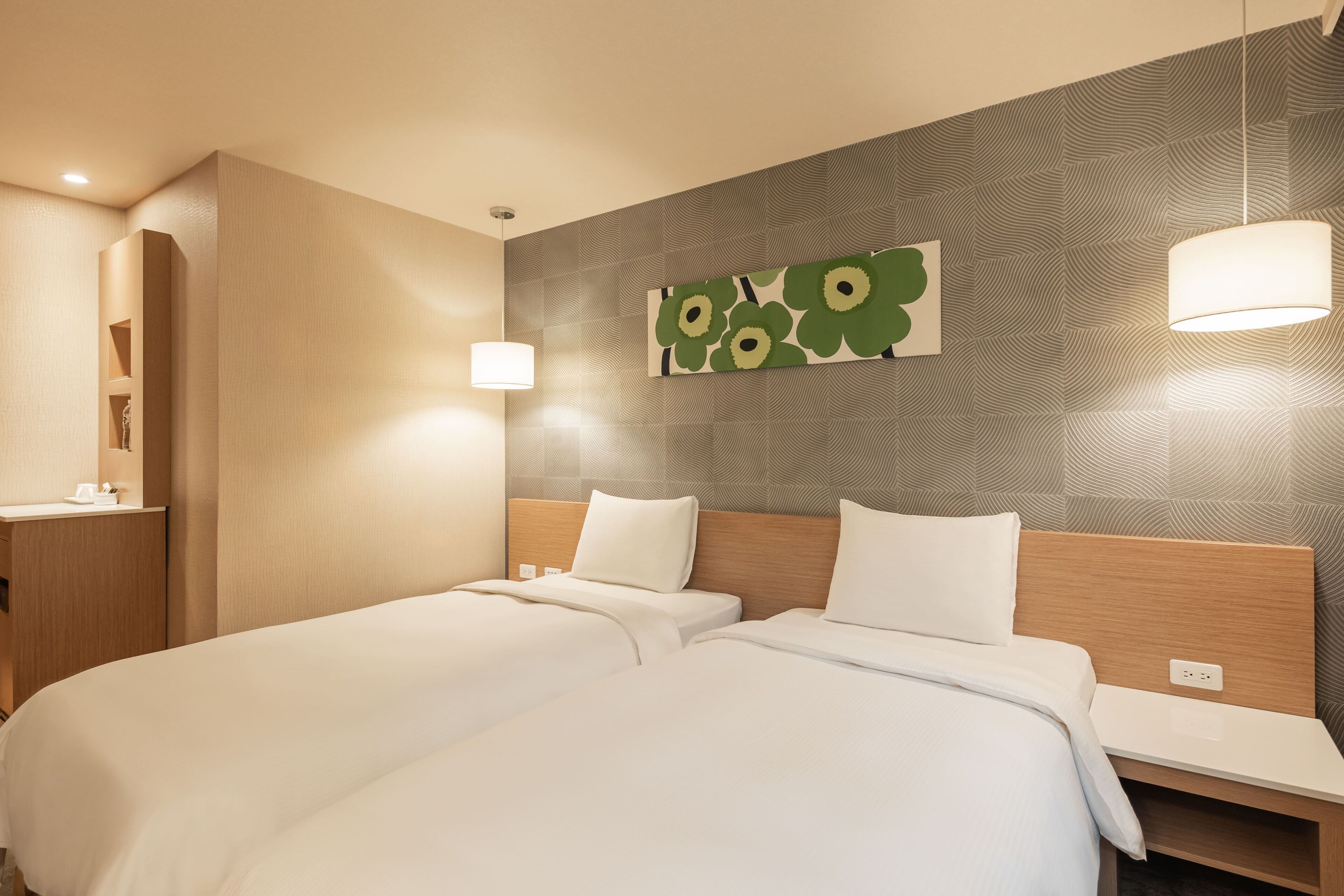 Habitación de hotel con dos camas, cabecero de madera, un cuadro en la pared y una mesita de noche con lámpara.