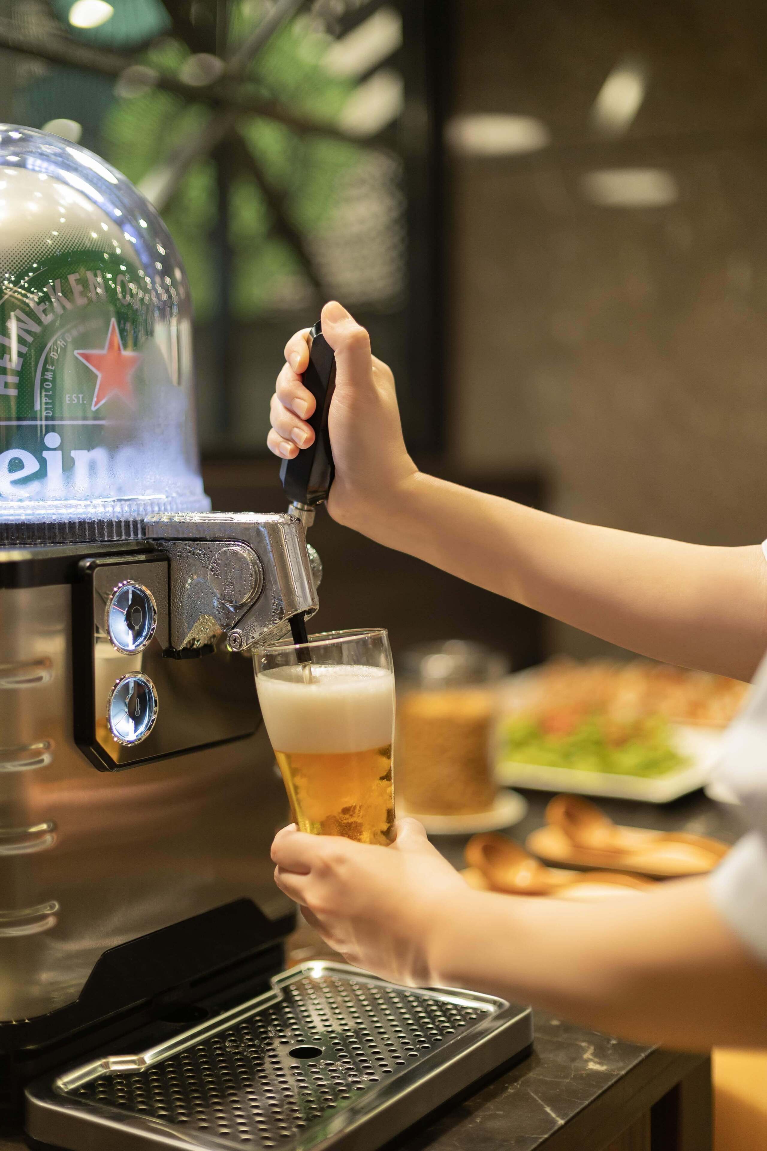 Una persona sirviendo cerveza de una llave a un vaso.