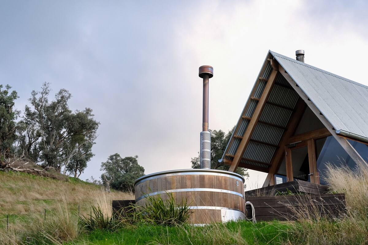 A modern building with a wooden exterior, a large cylindrical structure, and a slanted roof.