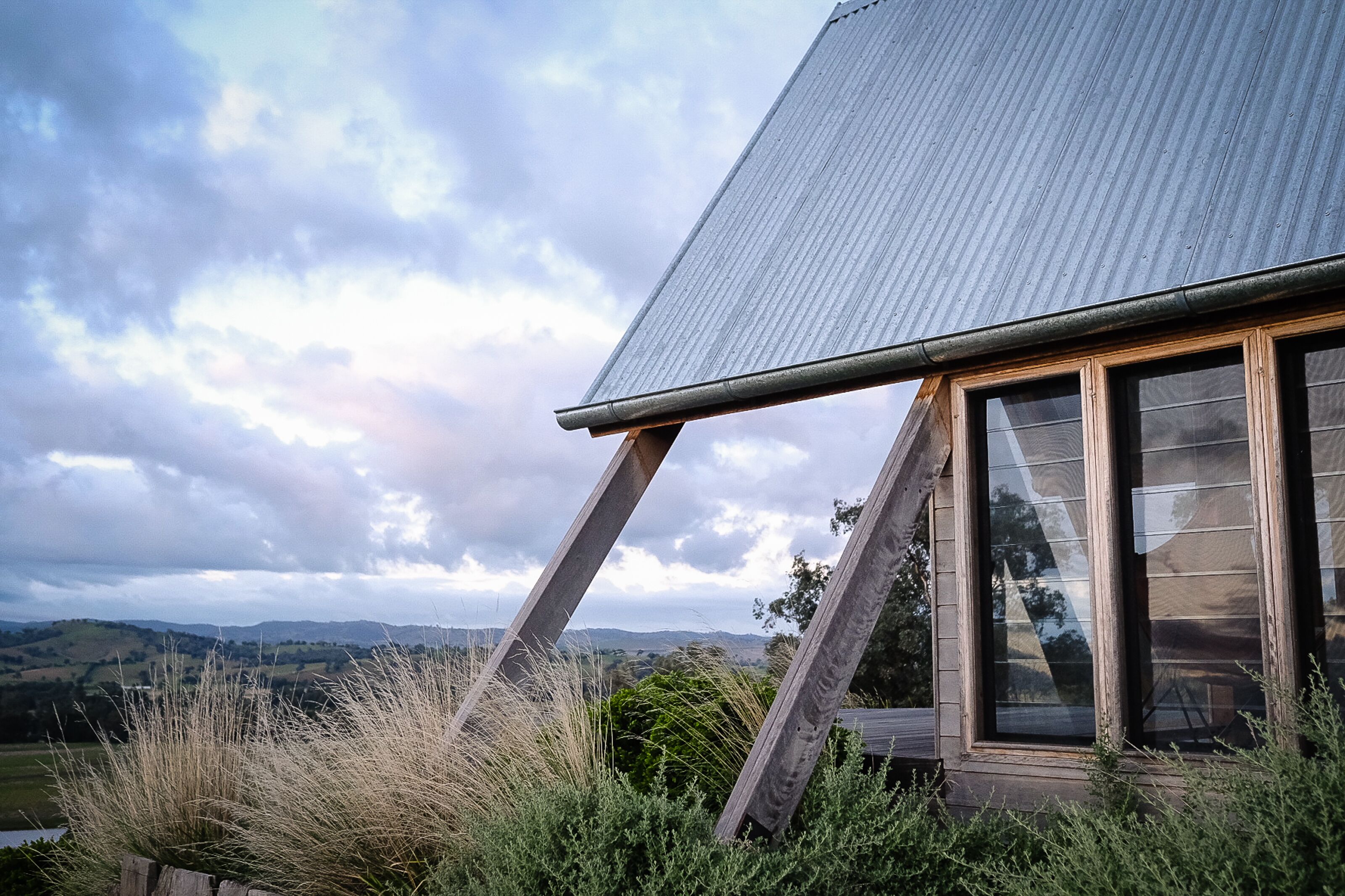 Una casa con techo inclinado y ventanas amplias.
