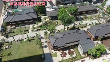 A residential area with traditional-style buildings, a central courtyard, and a small pond.