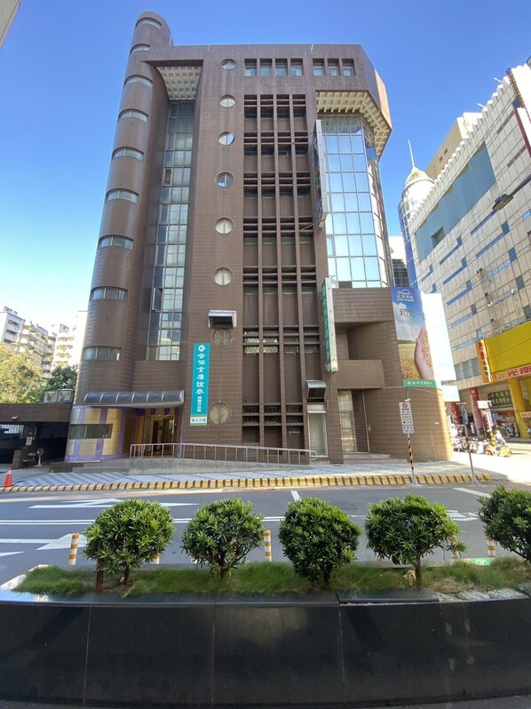 A modern building with a prominent entrance, multiple floors, and a mix of glass and brick facade. - 191 Hotel (Taoyuan City)