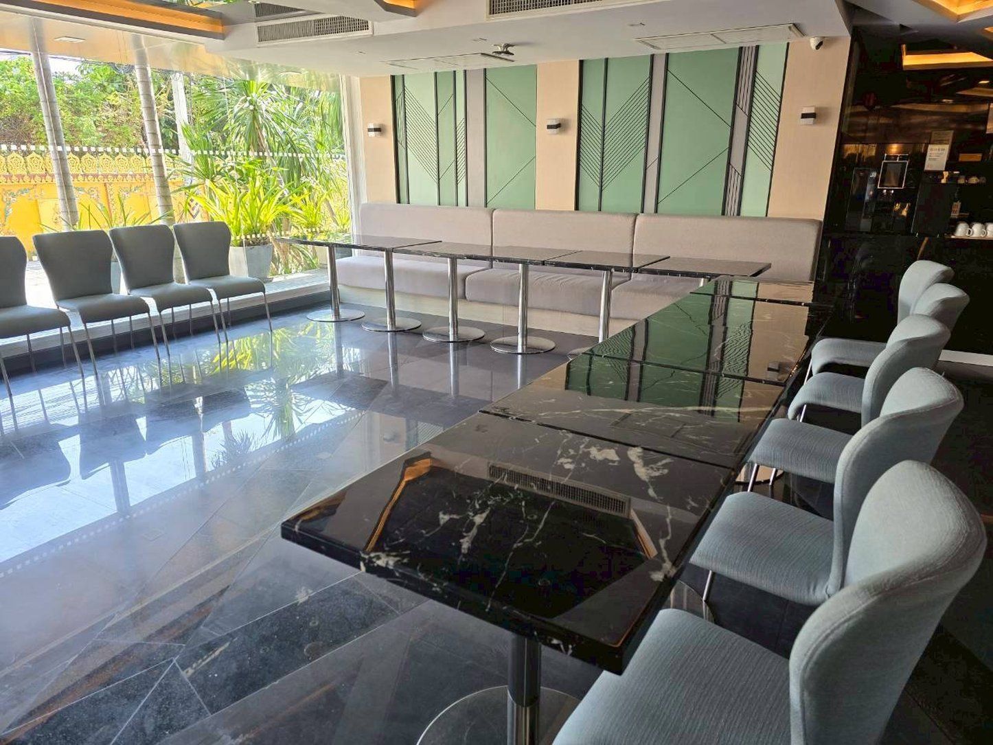 A modern bar area with seating and a glass-top table.