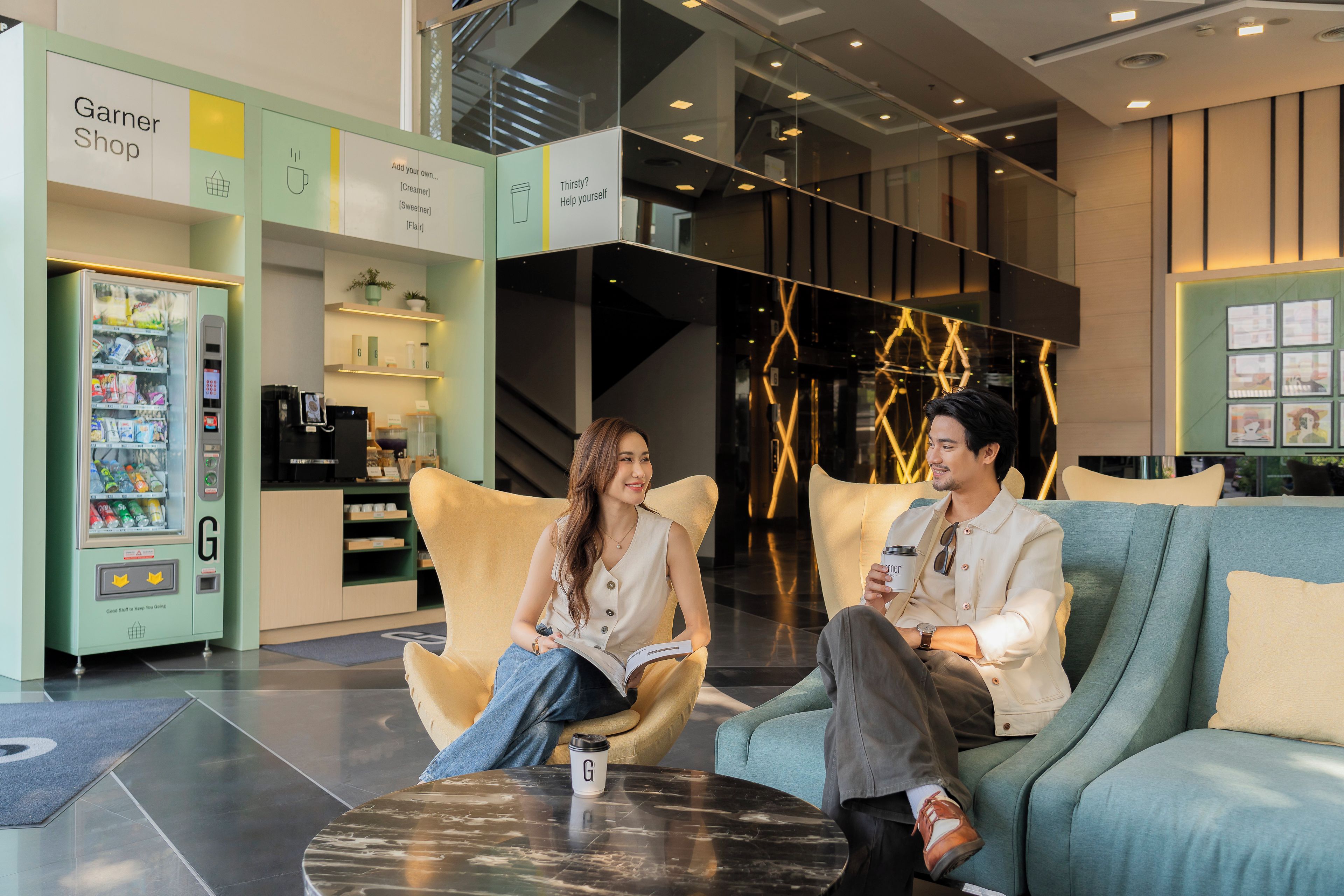 A modern interior with a seating area, a vending machine, and a counter labeled 'Garner Shop'.