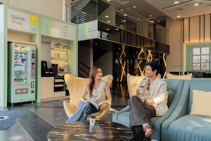 A modern interior with a seating area, a vending machine, and a counter labeled 'Garner Shop'.
