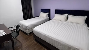 A hotel room with two single beds, a desk with a chair, and a dark-colored headboard. - Elmark Hotel Johor (Johor Bahru)