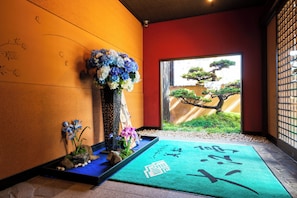 A traditional Japanese room with tatami flooring, a shoji screen, and a bonsai tree visible through a sliding door. - Seaside Hotel Mimatu Oetei (Beppu)