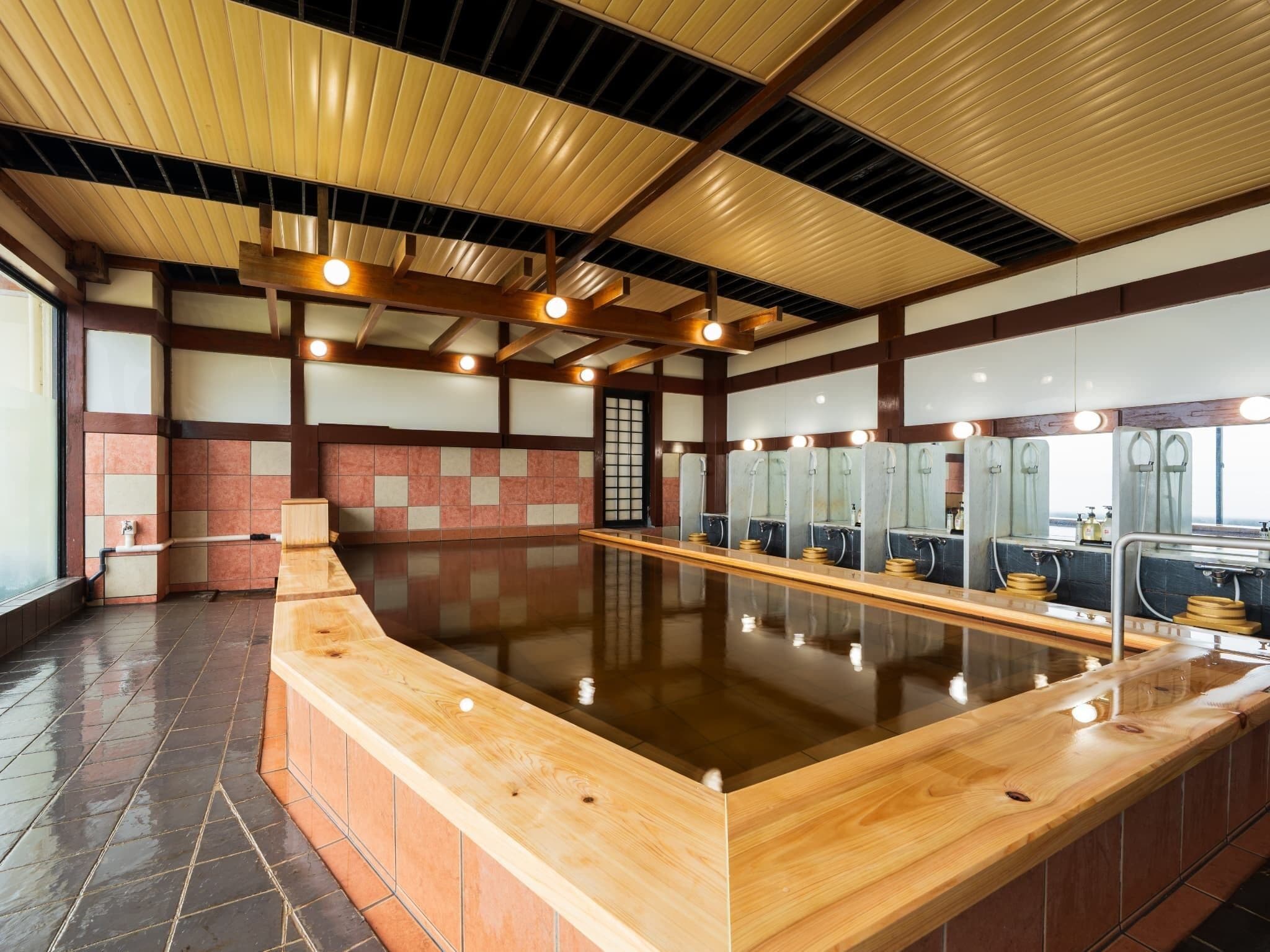 Una amplia piscina interior con bancos de madera y varias estaciones de cambiadores.