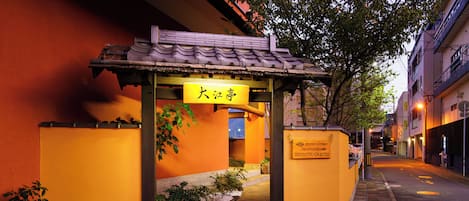 A traditional Japanese building with a yellow entrance and signage.