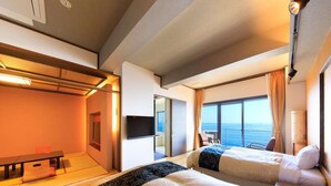 Una habitación de hotel moderna con dos camas, un escritorio y un ventanal con vistas al mar.
