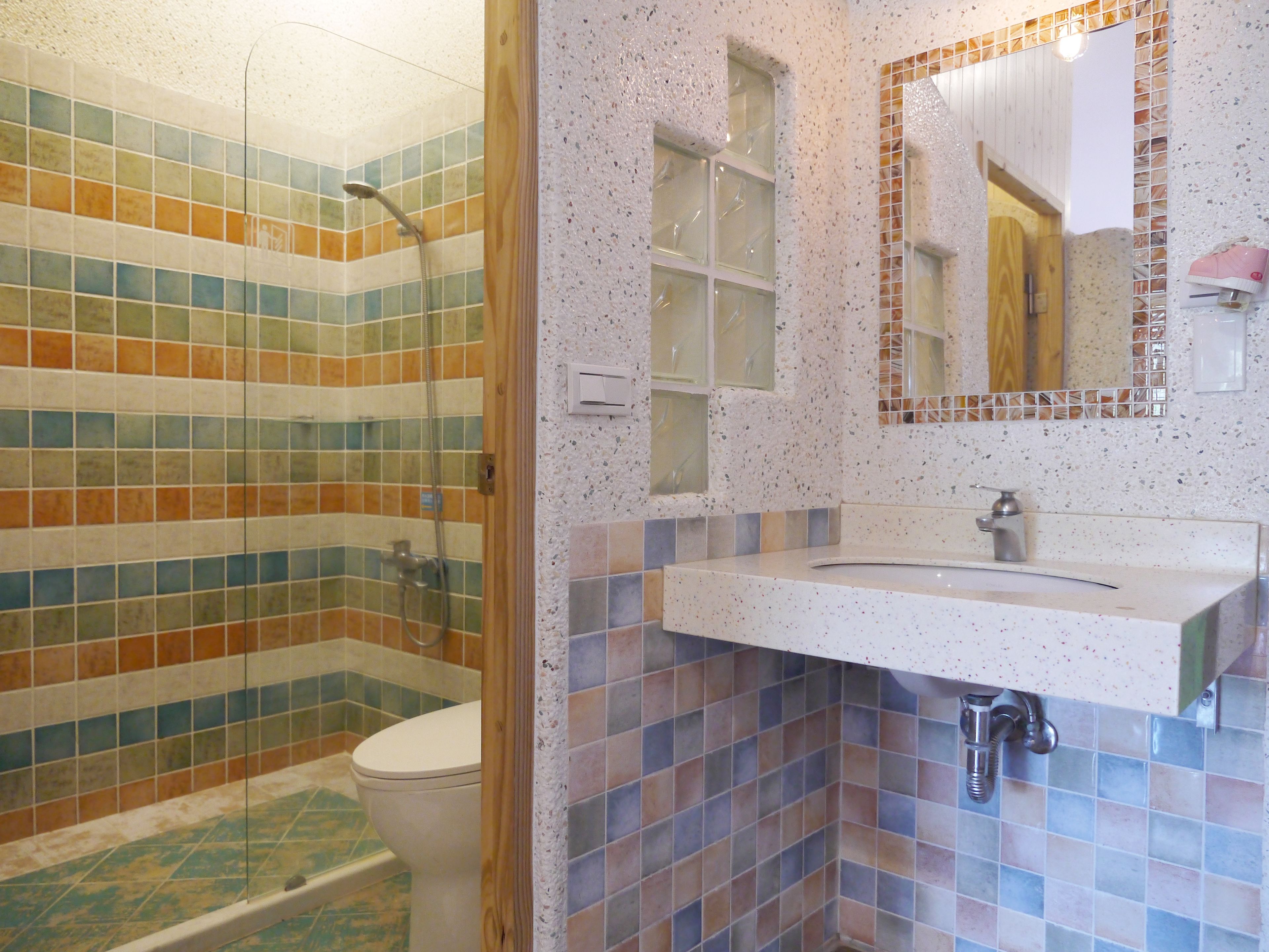 A bathroom with a shower, toilet, and sink.