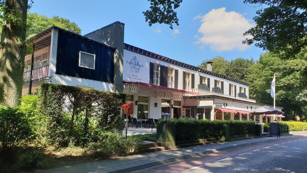 A hotel with a red awning, a balcony, and a sign indicating it is a hotel and restaurant. - Nol in 't Bosch (Wageningen)